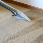 Cleaning a dirty carpet right up to the skirting board
